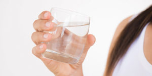 Woman holding glass of water