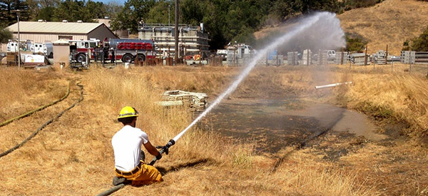 Firefighter putting out grass fire