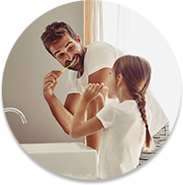 Un padre y su hija cepillándose los dientes