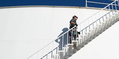 Worker climbing stairs on water tank