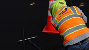 Crew member working on pipe in the street