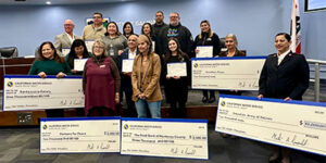 Destinatarios de las donaciones de Operation Gobble sisteniendo cheques